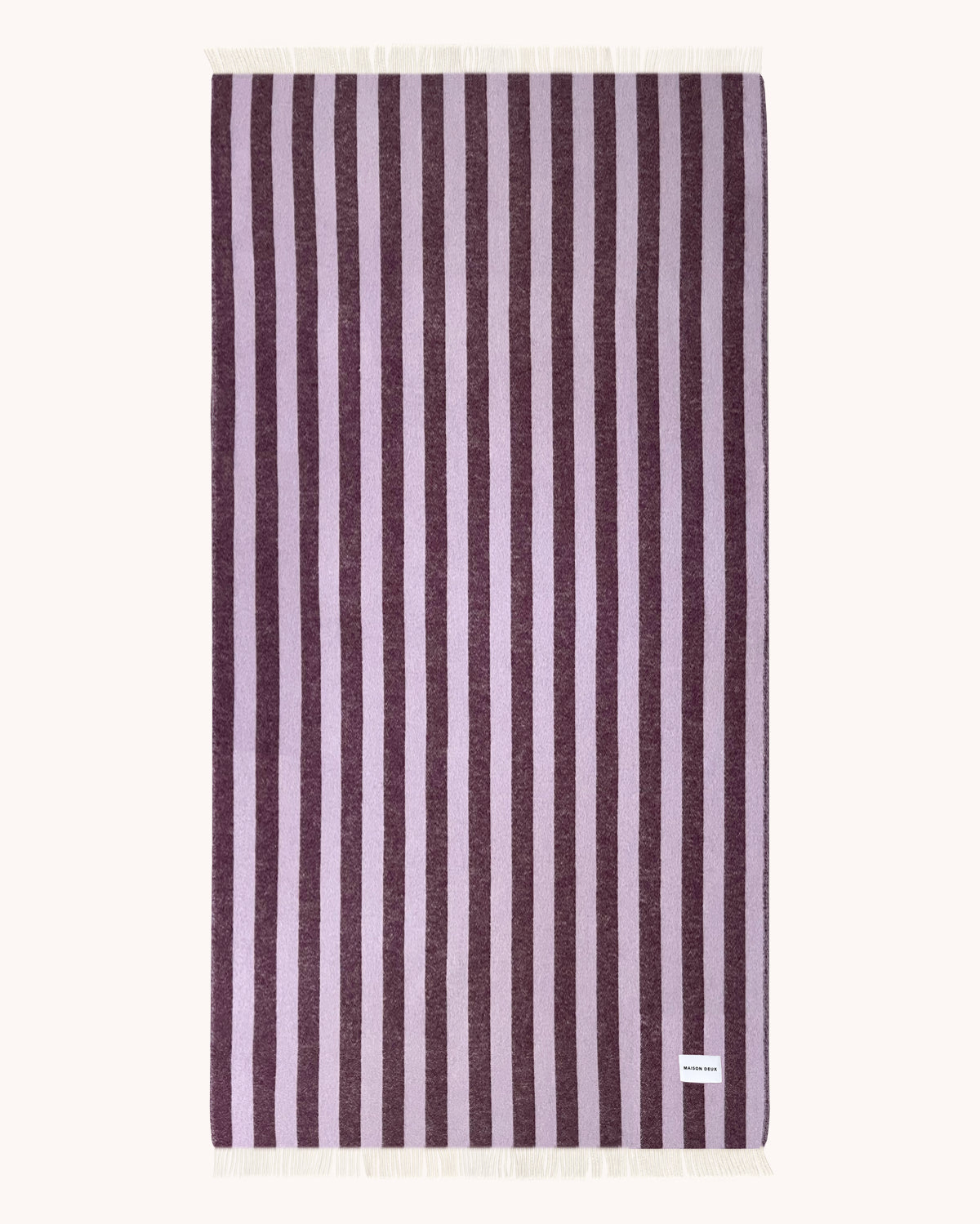 Lilac and aubergine striped wool blanket folded with fringe detail