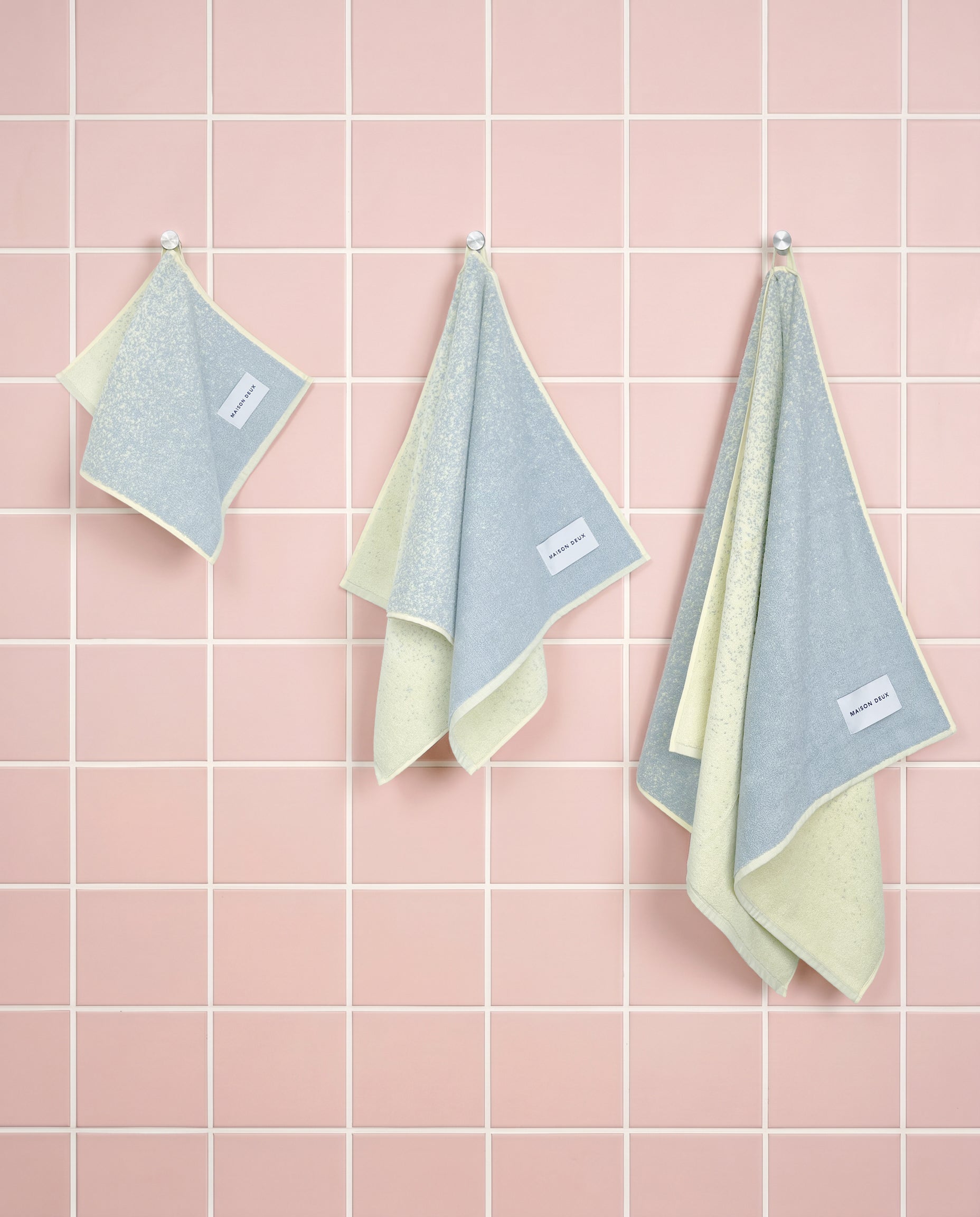 Blue and butter yellow gradient organic cotton towels shown in guest, hand and bath sizes
