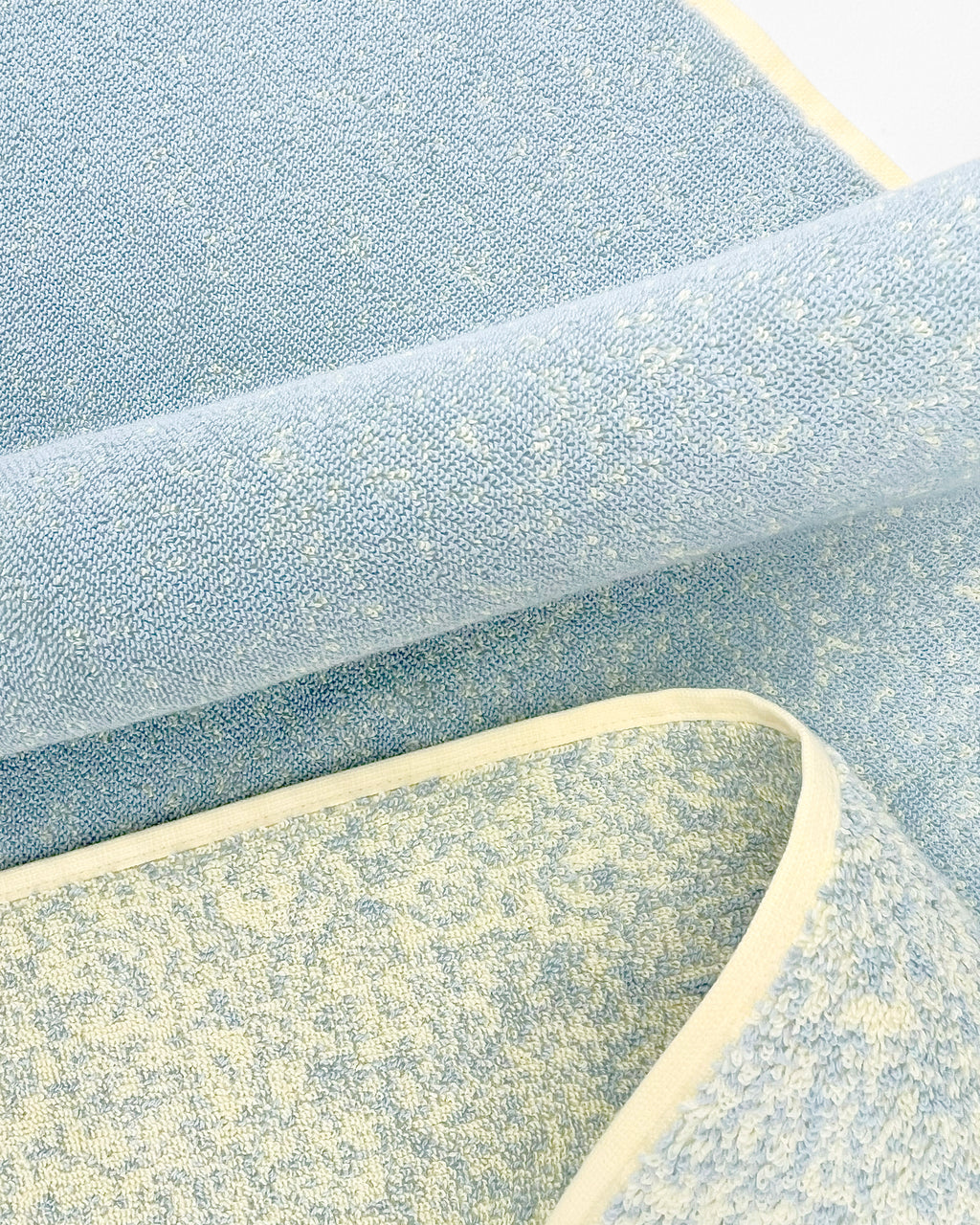 Close-up of dense GOTS-certified terry weave, blue to butter yellow gradient