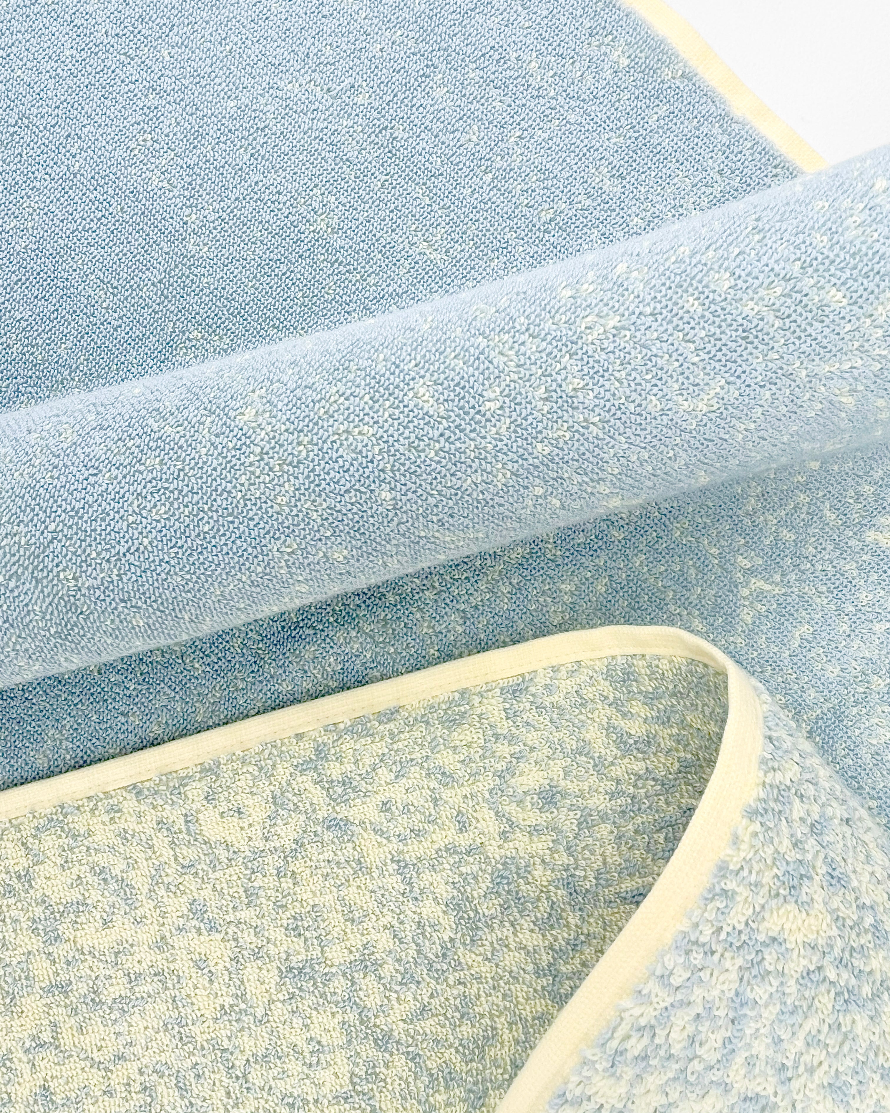 Close-up of dense GOTS-certified terry weave, blue to butter yellow gradient