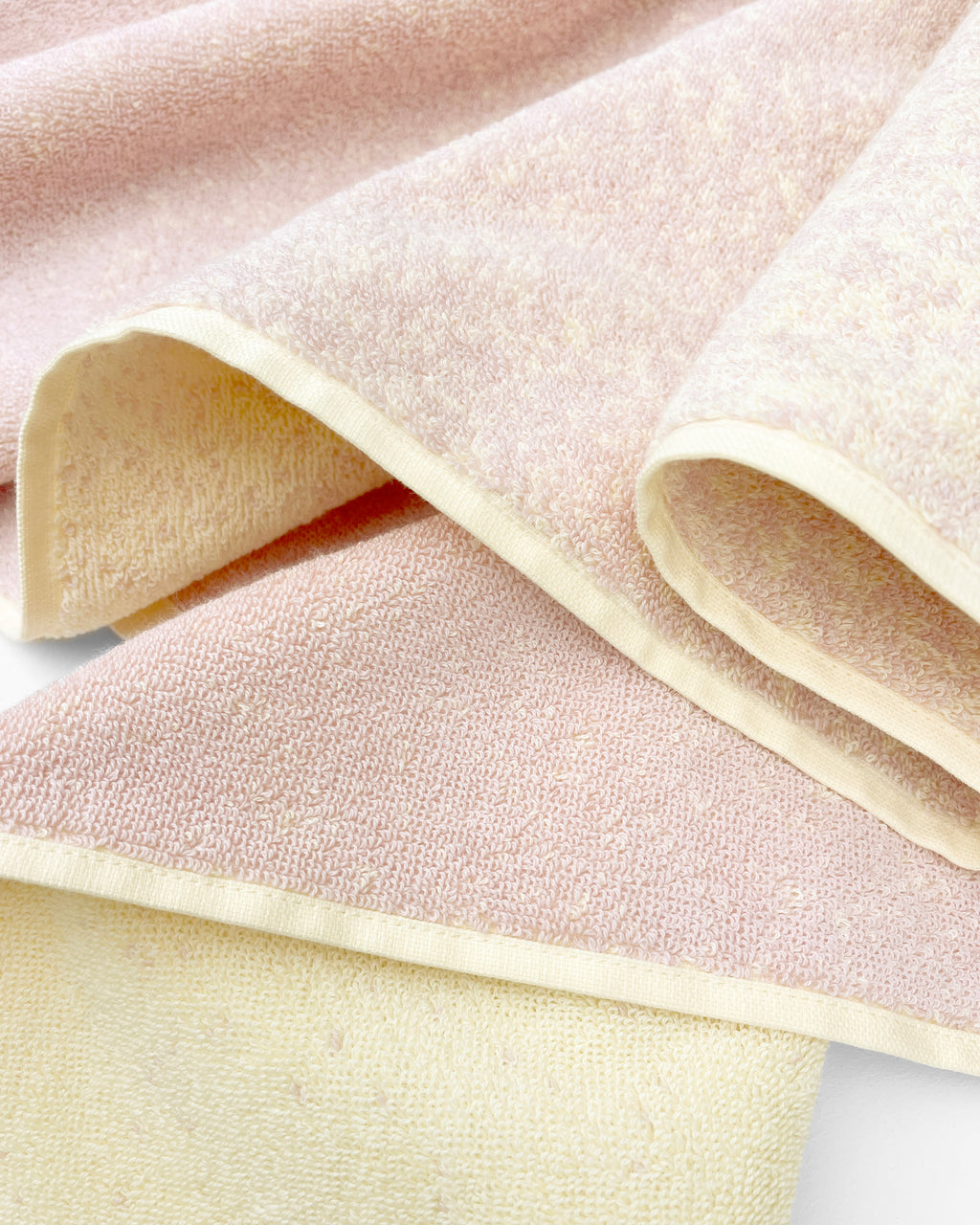 Close-up of dense GOTS-certified terry weave, butter yellow to pink gradient