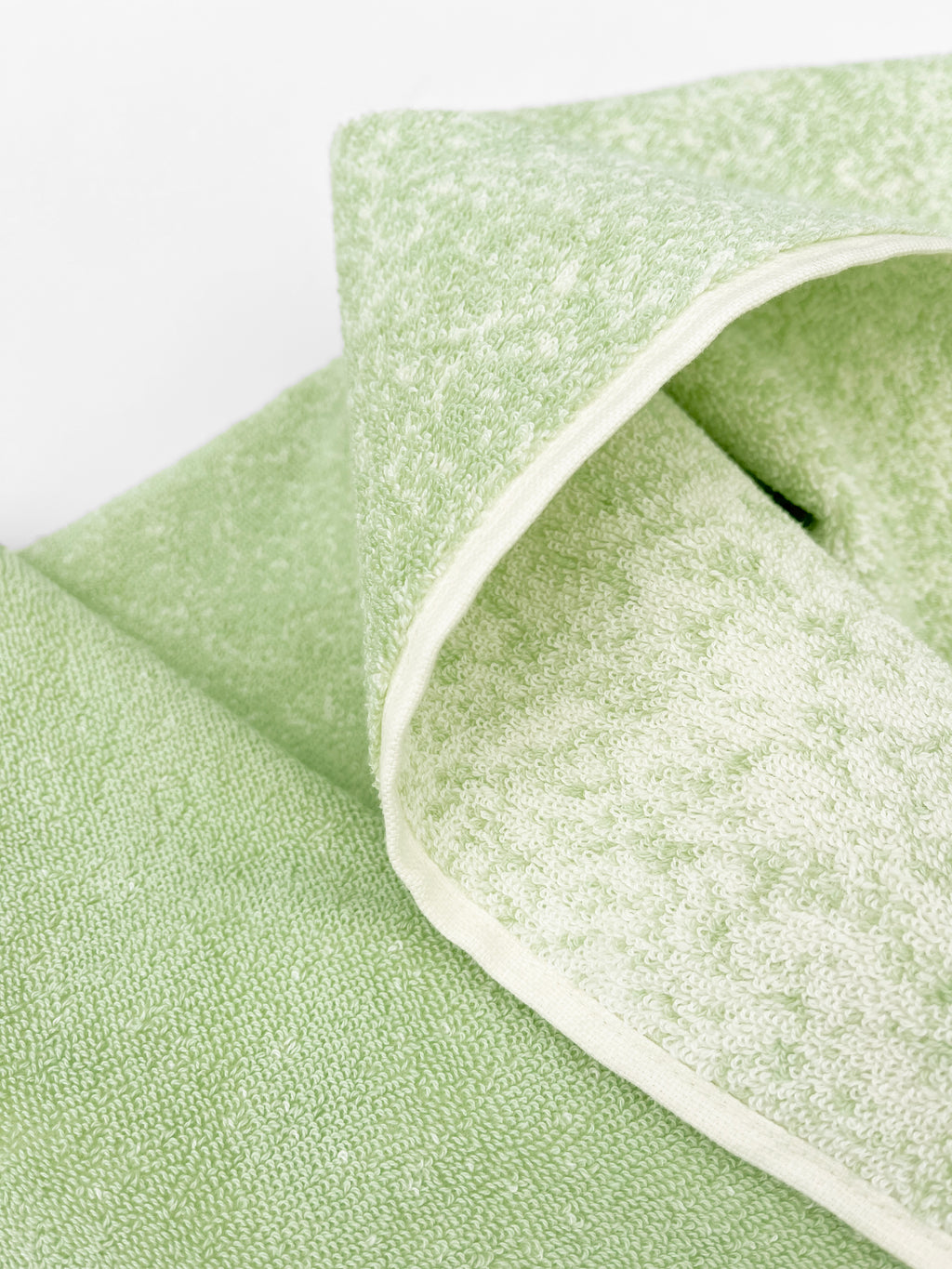 Close-up of dense GOTS-certified terry weave, sage to vanilla gradient