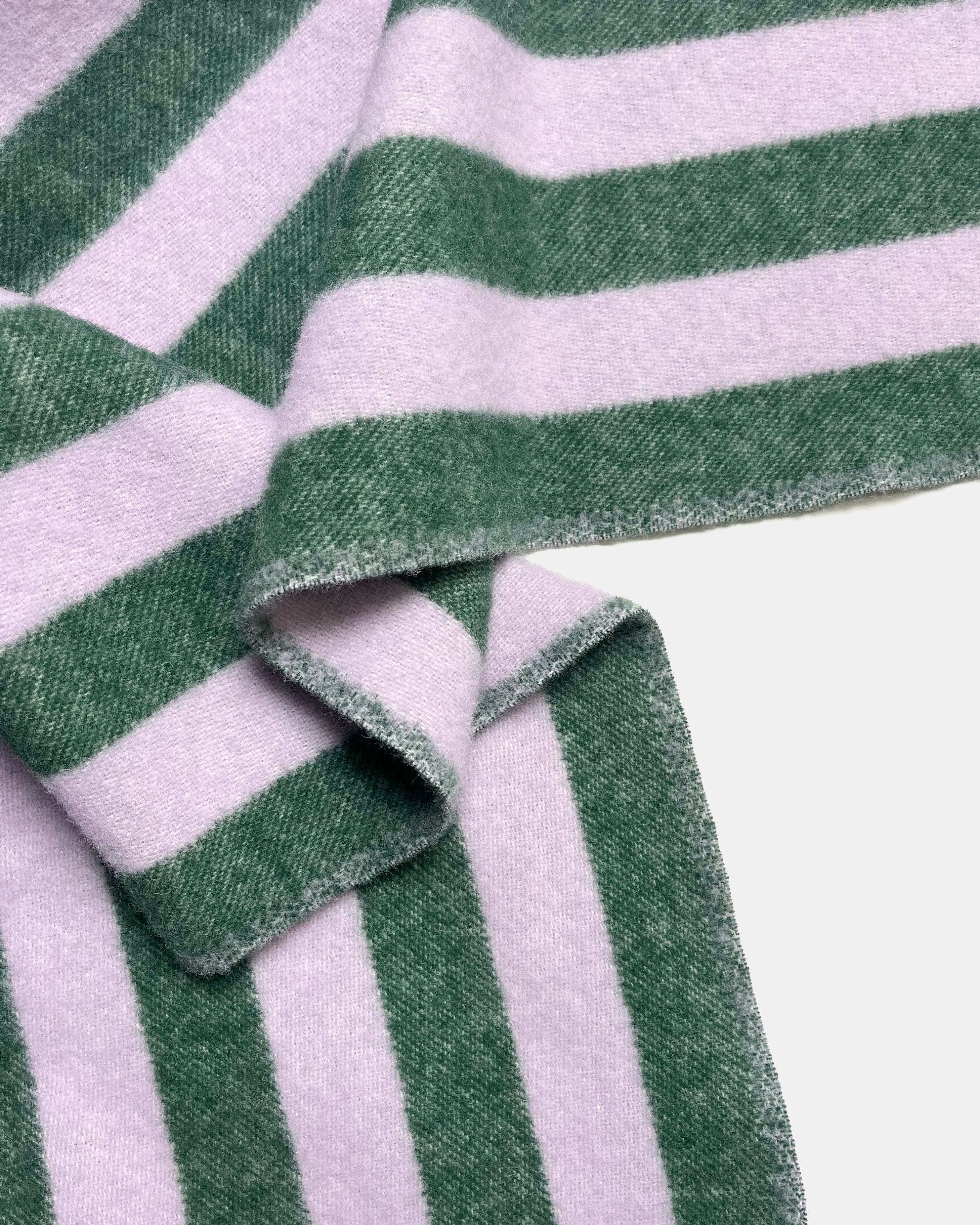 Close-up of folded lilac and green striped wool blanket
