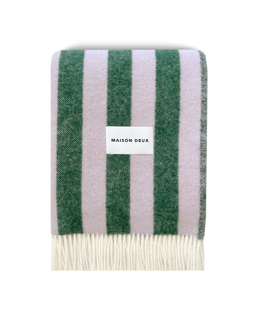 Lilac and green striped wool blanket folded with fringe detail

