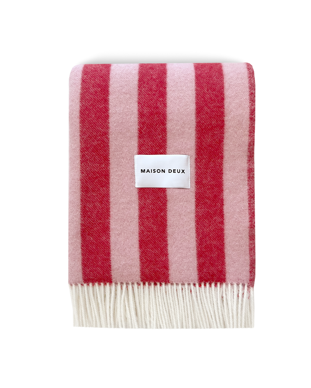 Pink and cherry red striped wool blanket folded with fringe detail
