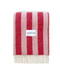 Pink and cherry red striped wool blanket folded with fringe detail
