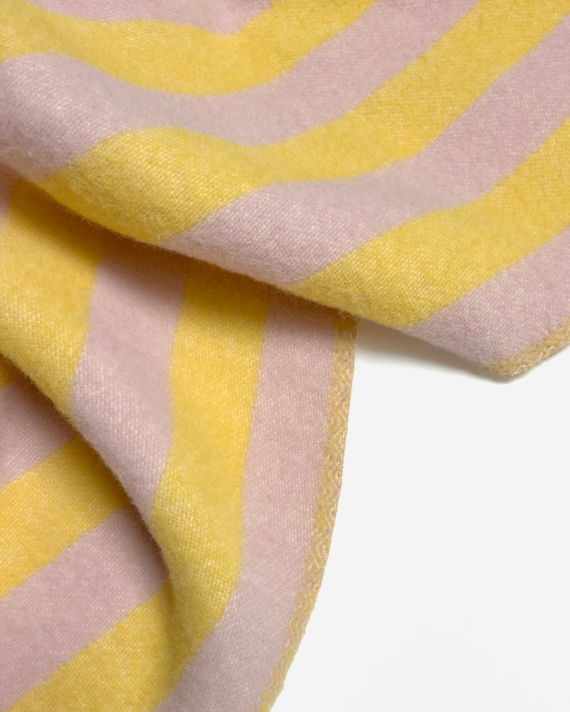 Close-up of folded pink and yellow striped wool blanket

