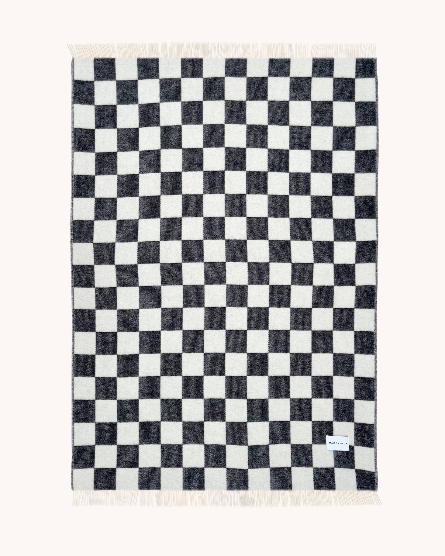 Black and white checkerboard wool throw shown flat
