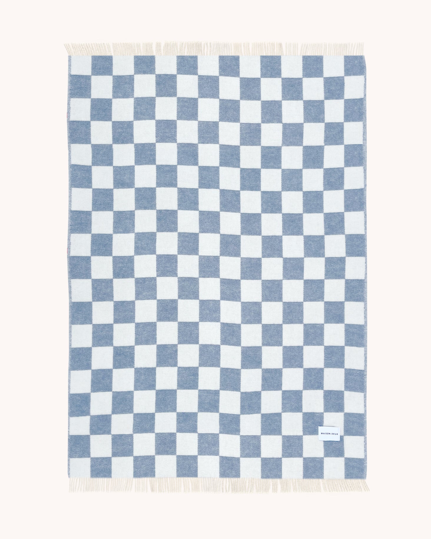 Denim blue and white checkerboard wool throw shown flat
