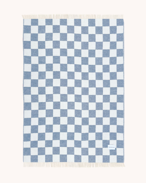 Denim blue and white checkerboard wool throw shown flat
