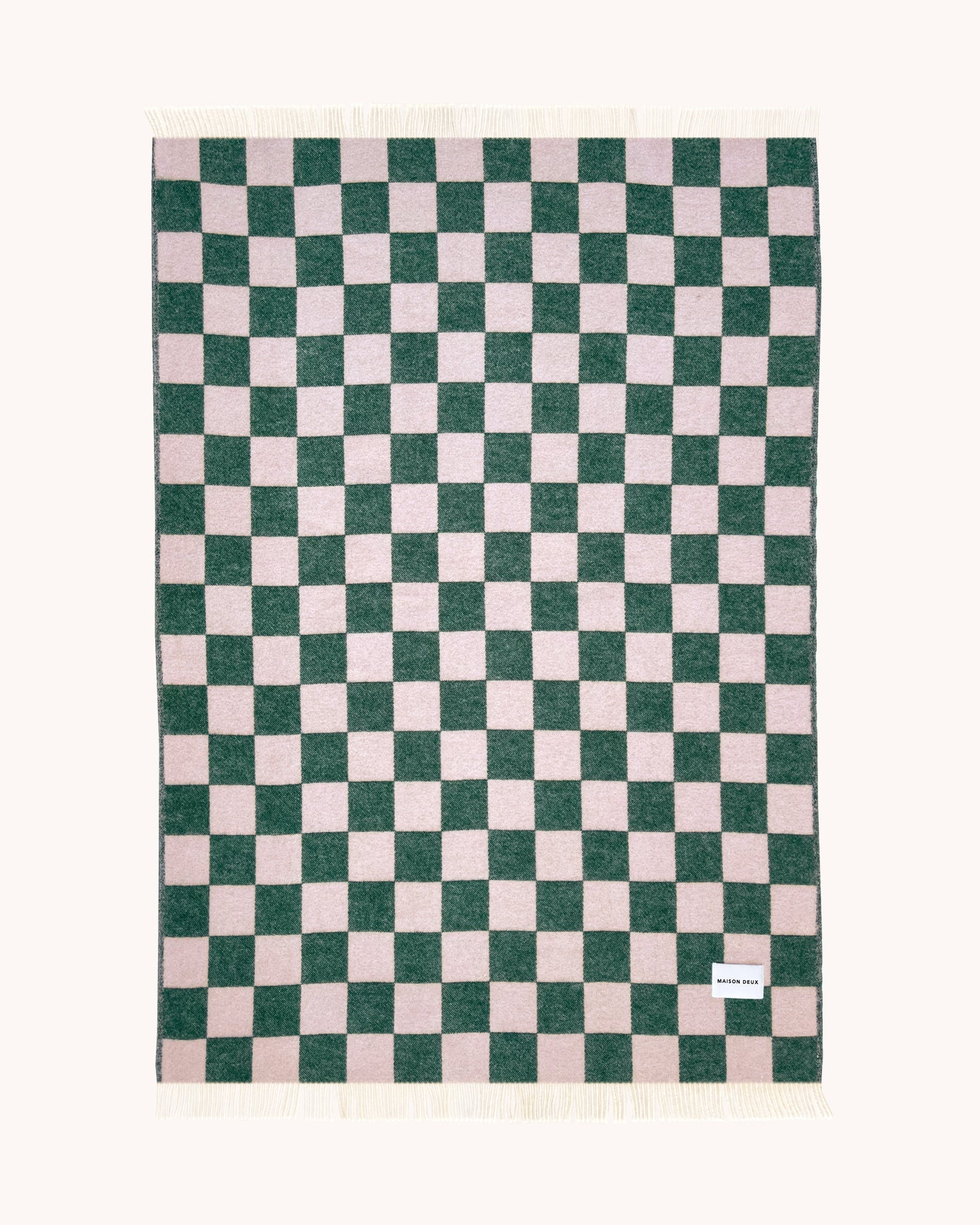 Green and pink checkerboard wool throw shown flat
