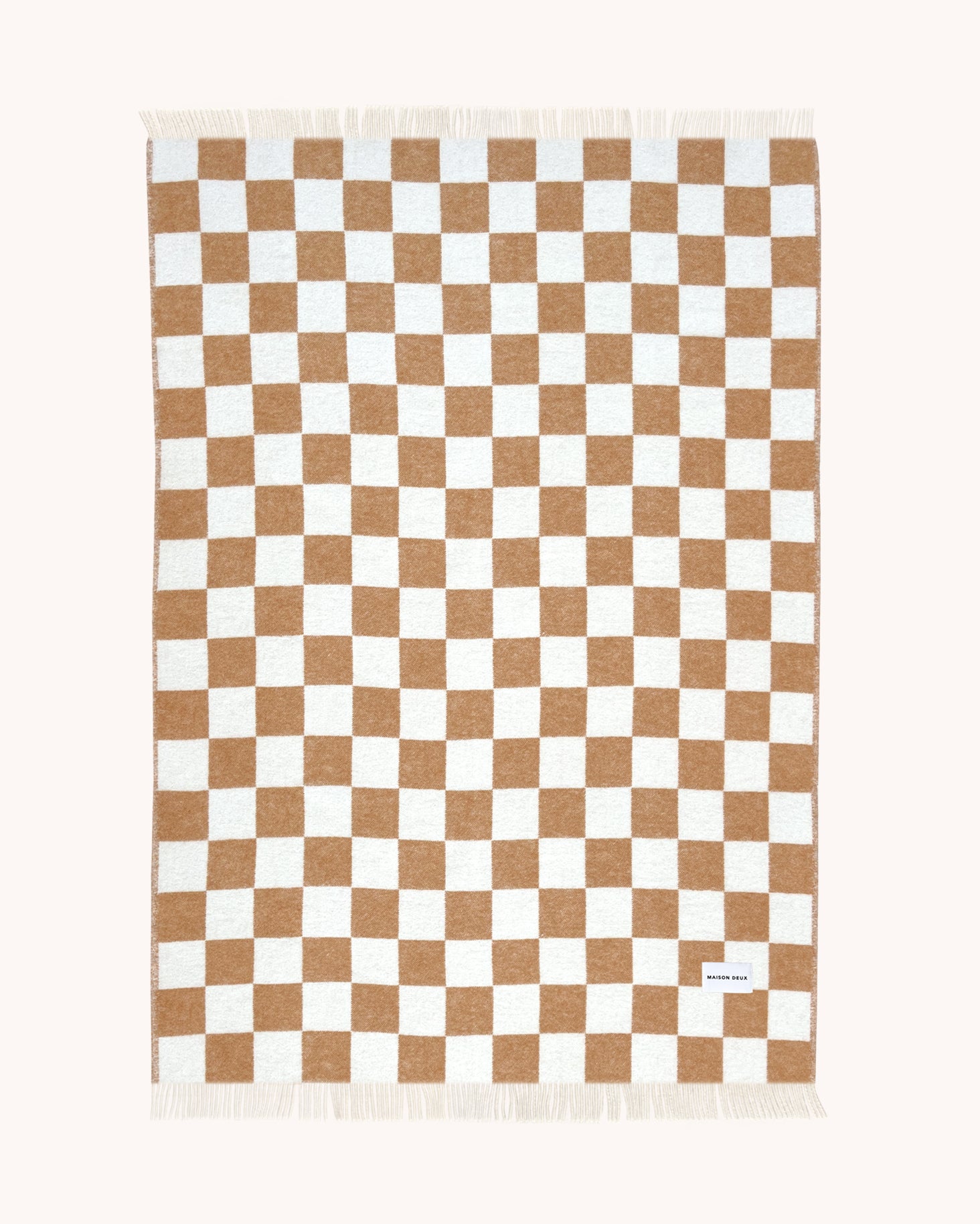 Terracotta and white checkerboard wool throw shown flat
