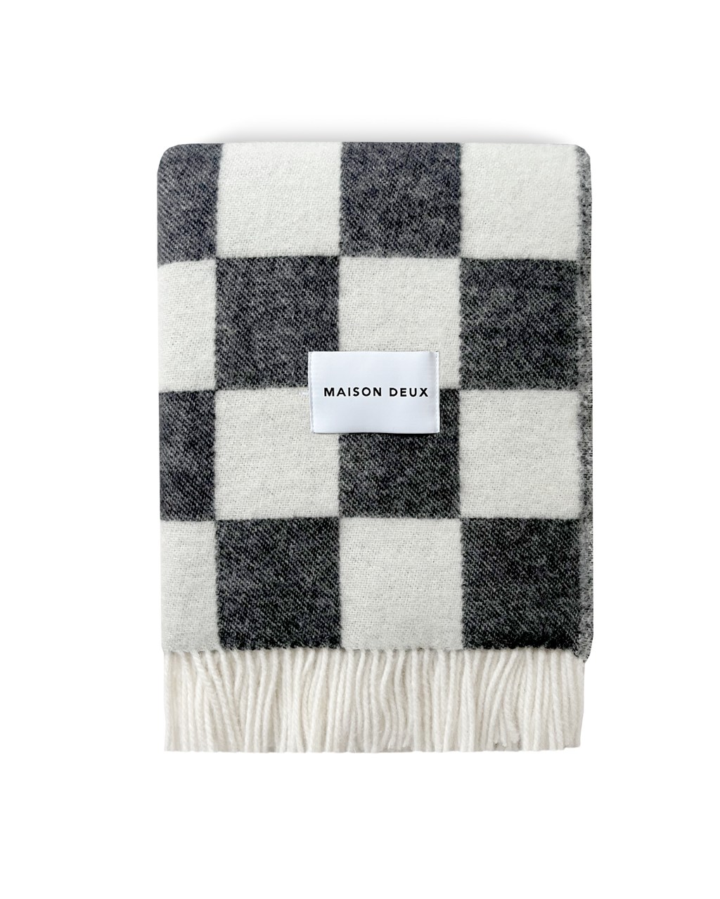 Black and white checkerboard wool blanket folded with fringe detail
