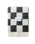 Black and white checkerboard wool blanket folded with fringe detail
