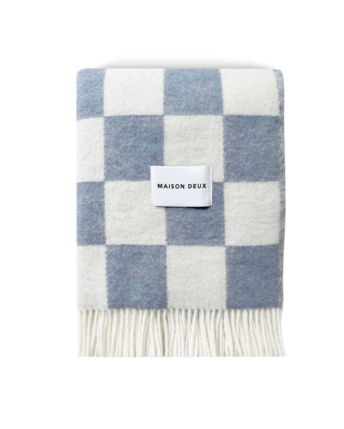 Denim blue and white checkerboard wool blanket folded with fringe detail
