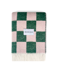 Green and pink checkerboard wool blanket folded with fringe detail
