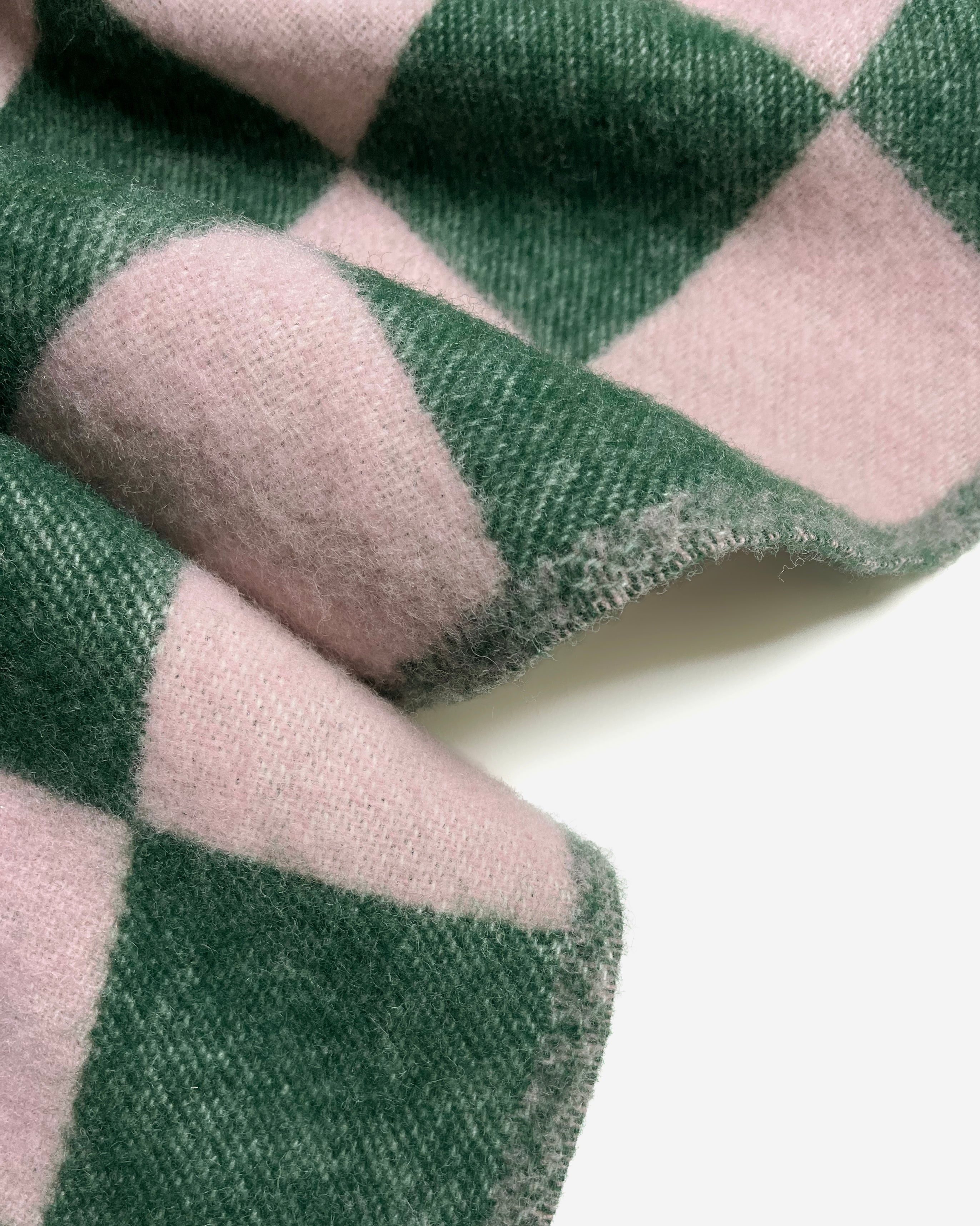 Close-up of green and pink checkerboard wool blanket showing reverse side
