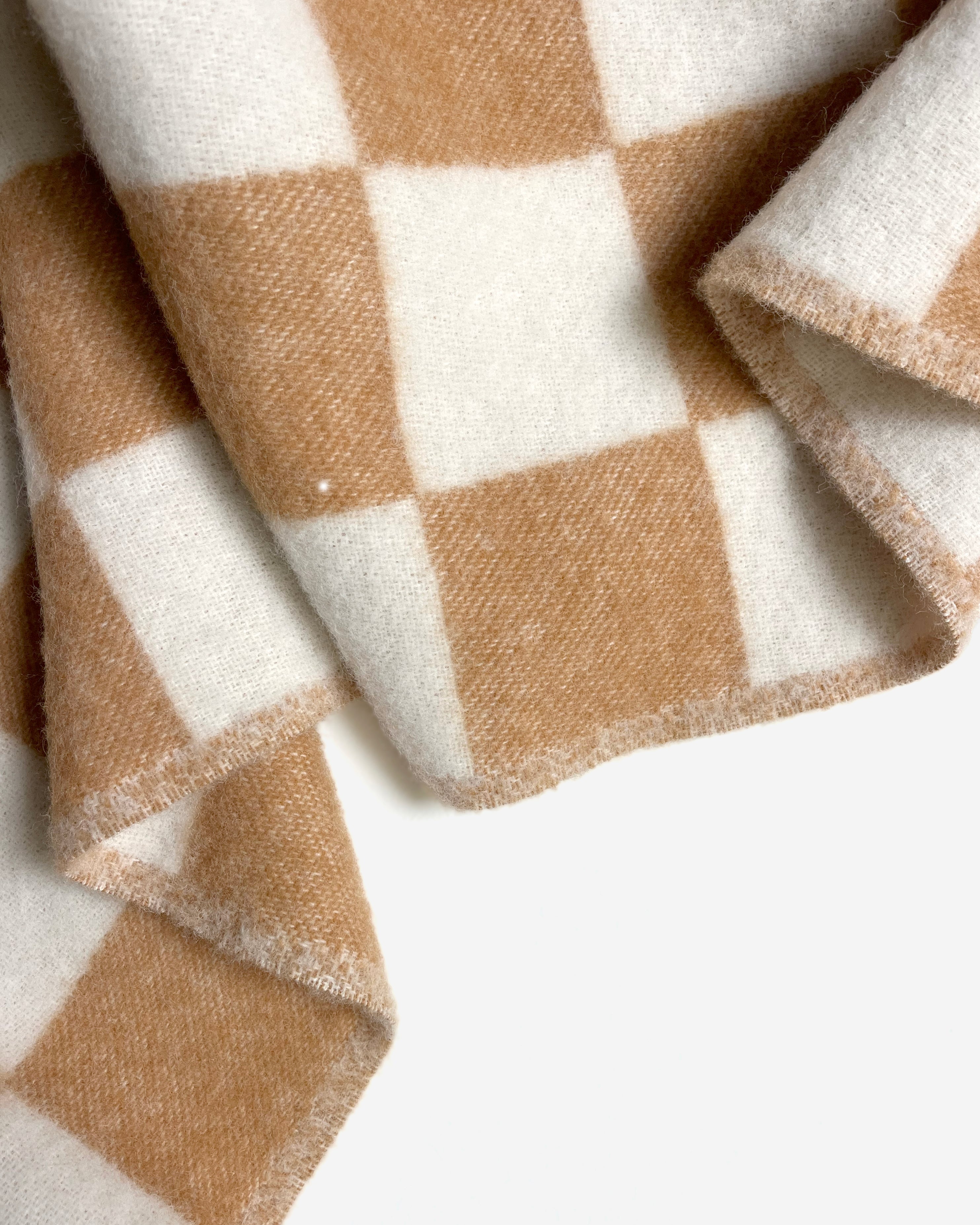 Close-up of folded terracotta and white checkerboard wool blanket

