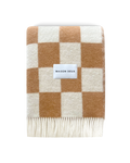 Terracotta and white checkerboard wool blanket folded with fringe detail
