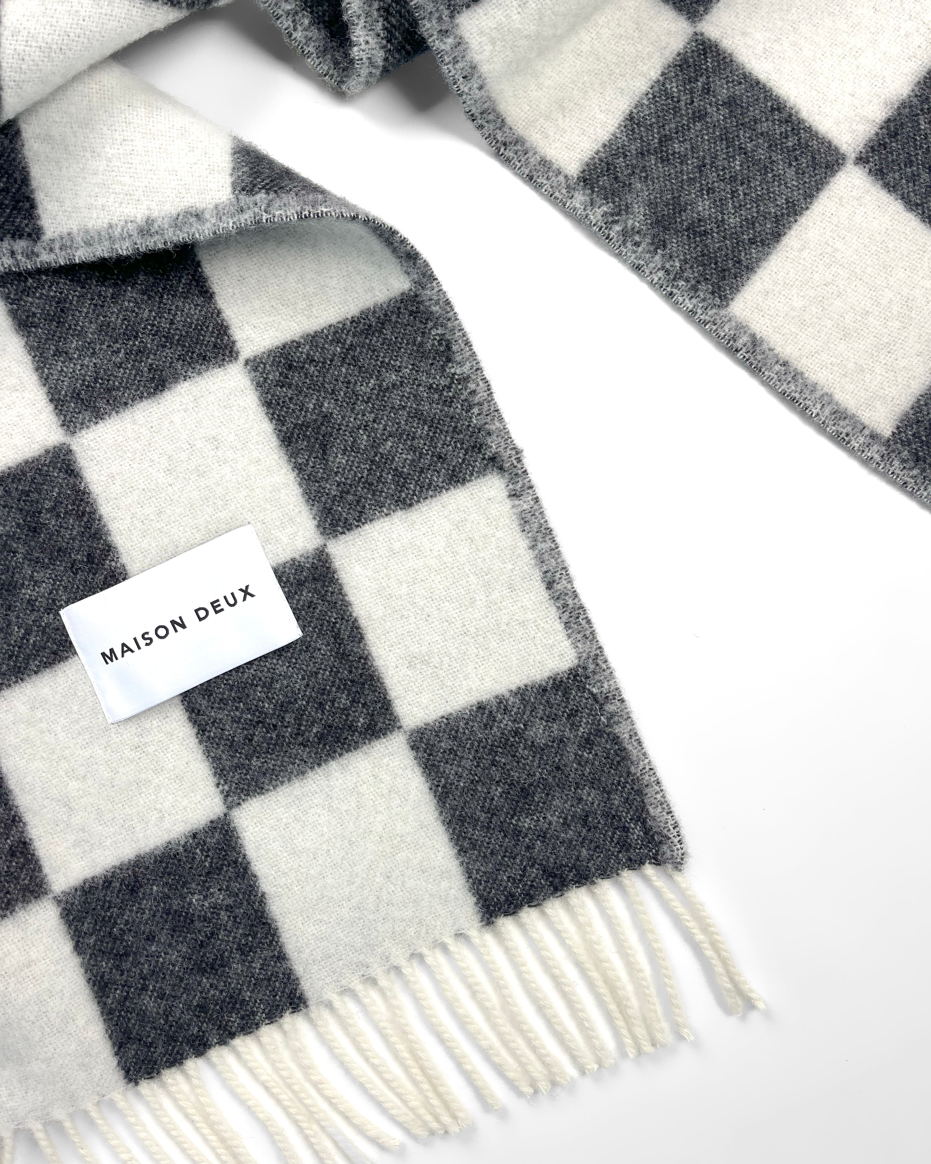 Close-up of twisted black and white checkerboard wool plaid with fringe
