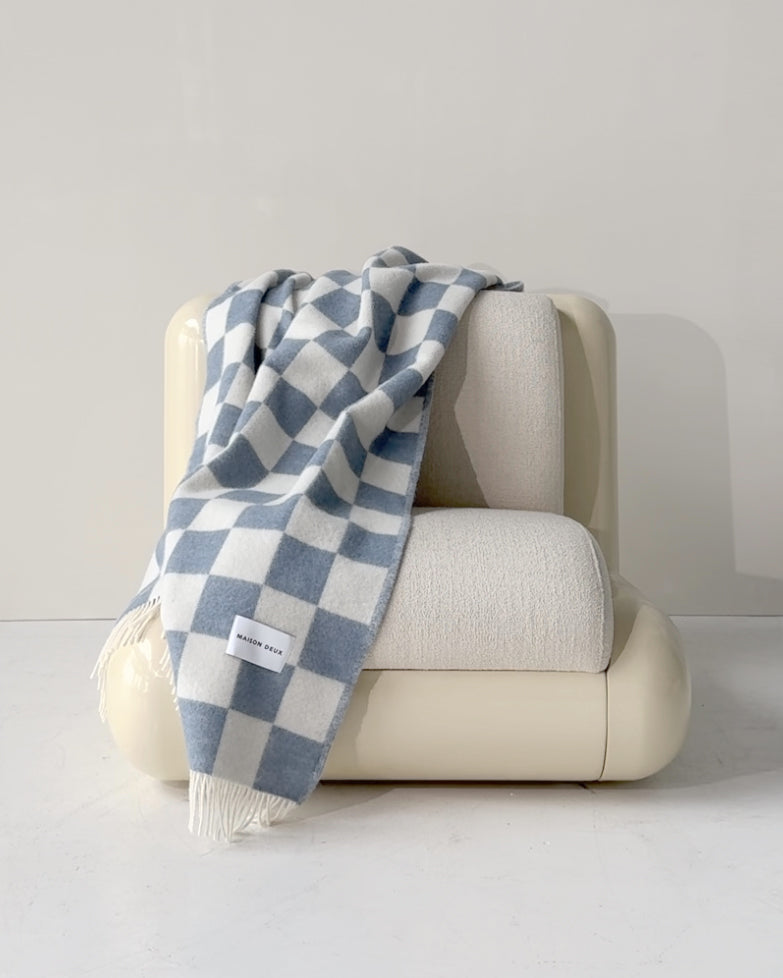 Denim blue and white checkerboard wool plaid draped over armchair
