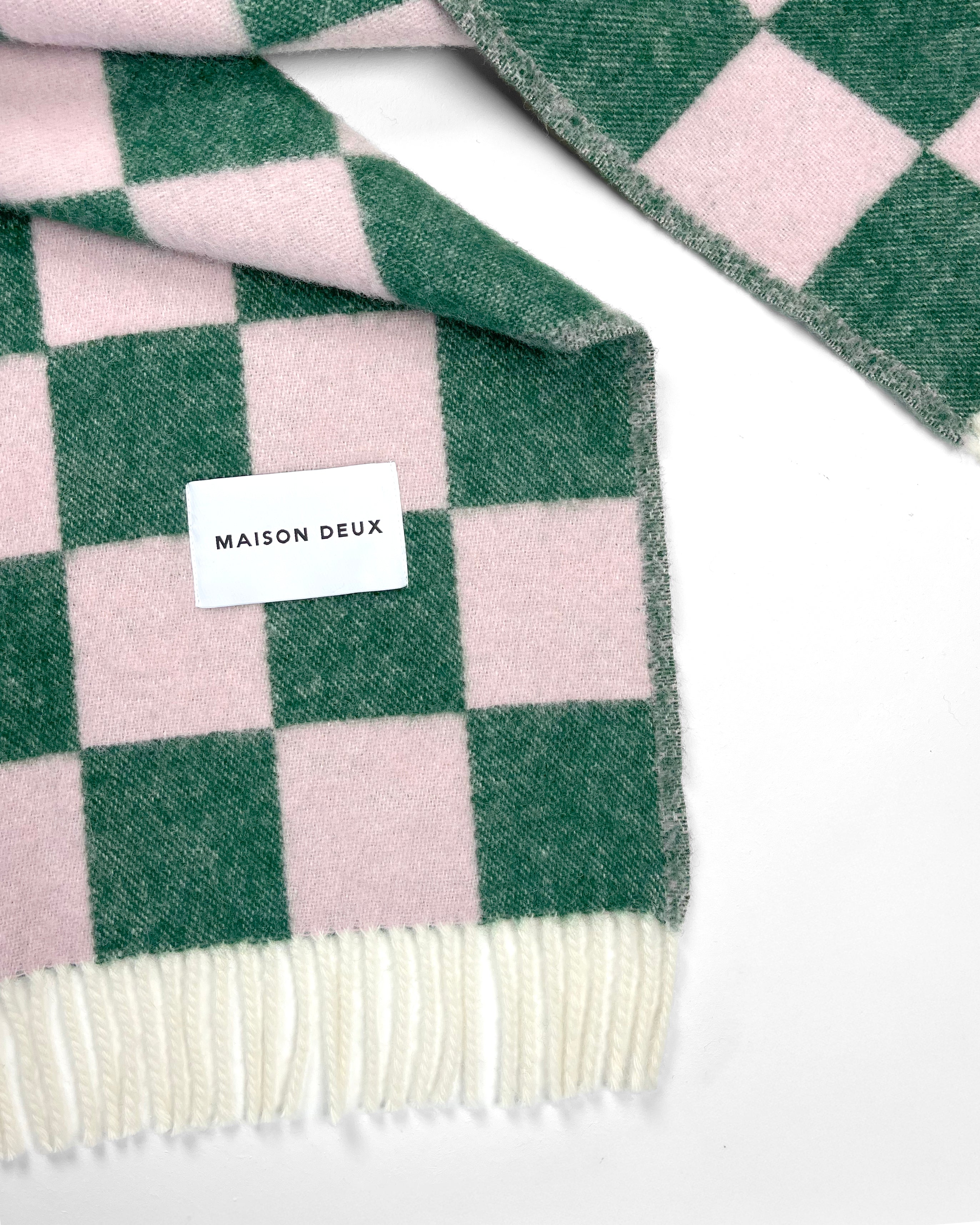 Close-up of green and pink checkerboard wool plaid with fringe
