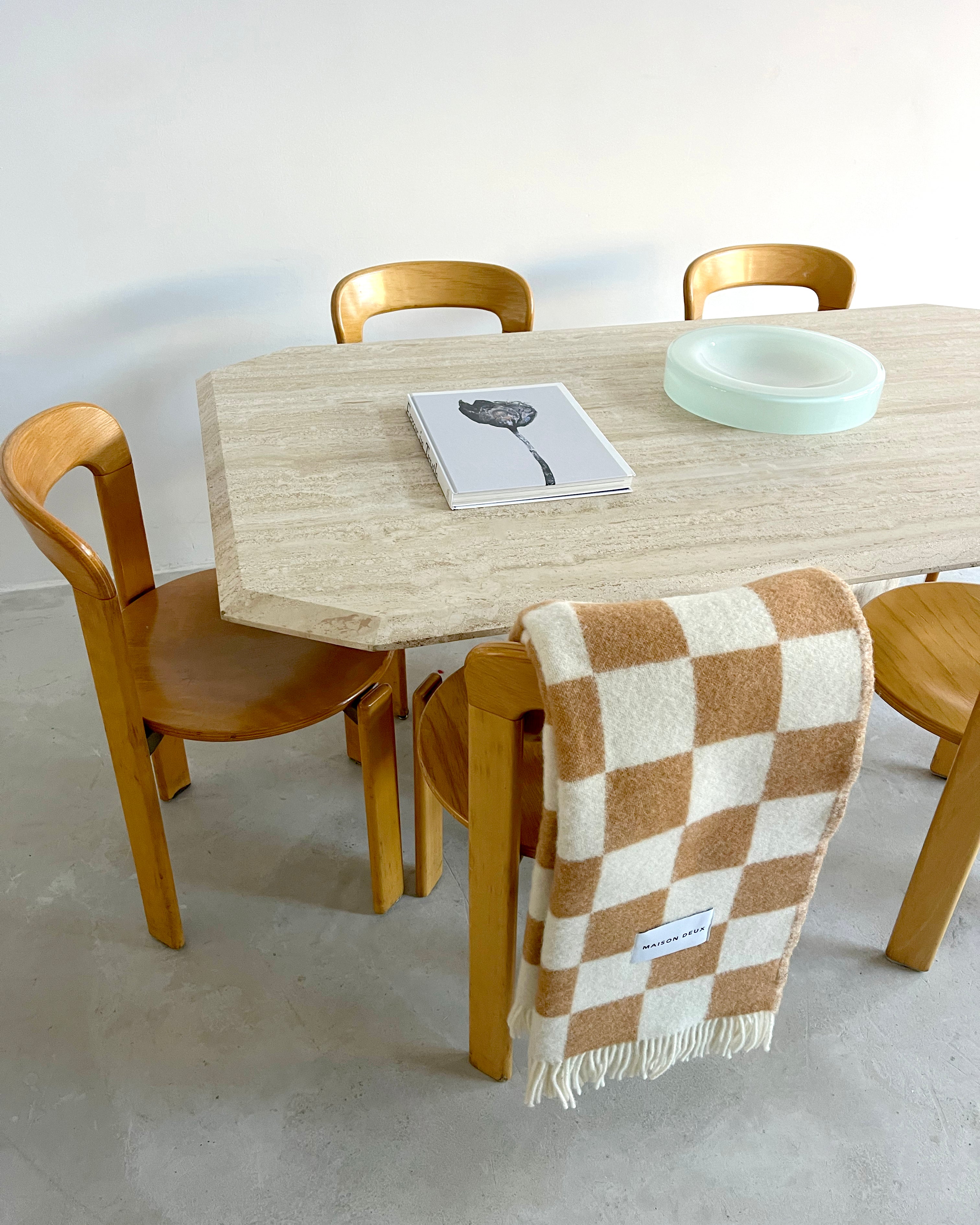 Terracotta and white checkerboard wool plaid draped over dining chair
