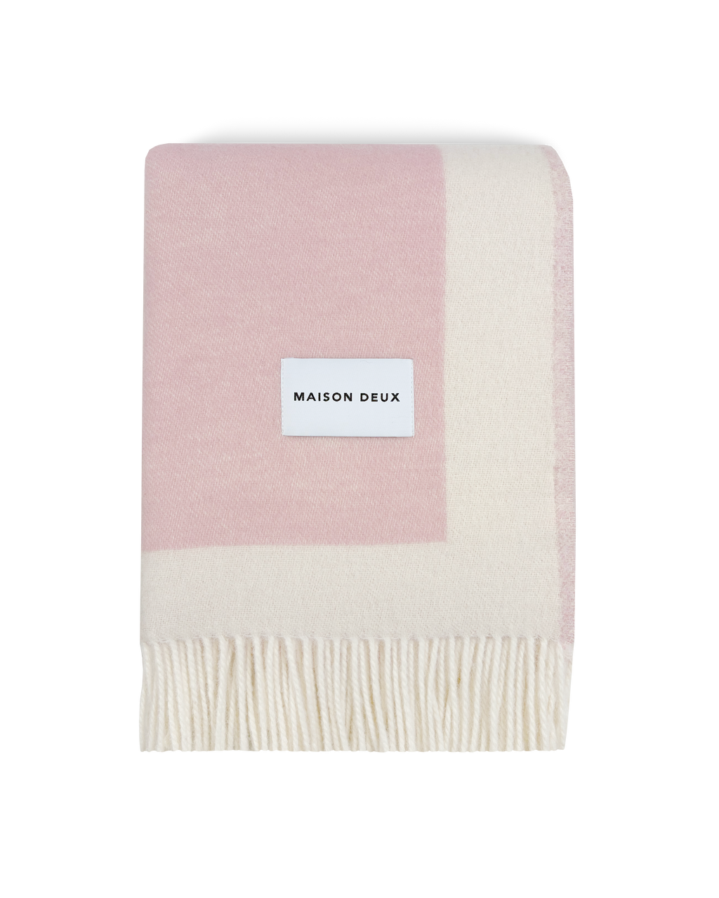 Pink and cream wool blanket folded with fringe detail
