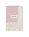 Pink and cream wool blanket folded with fringe detail

