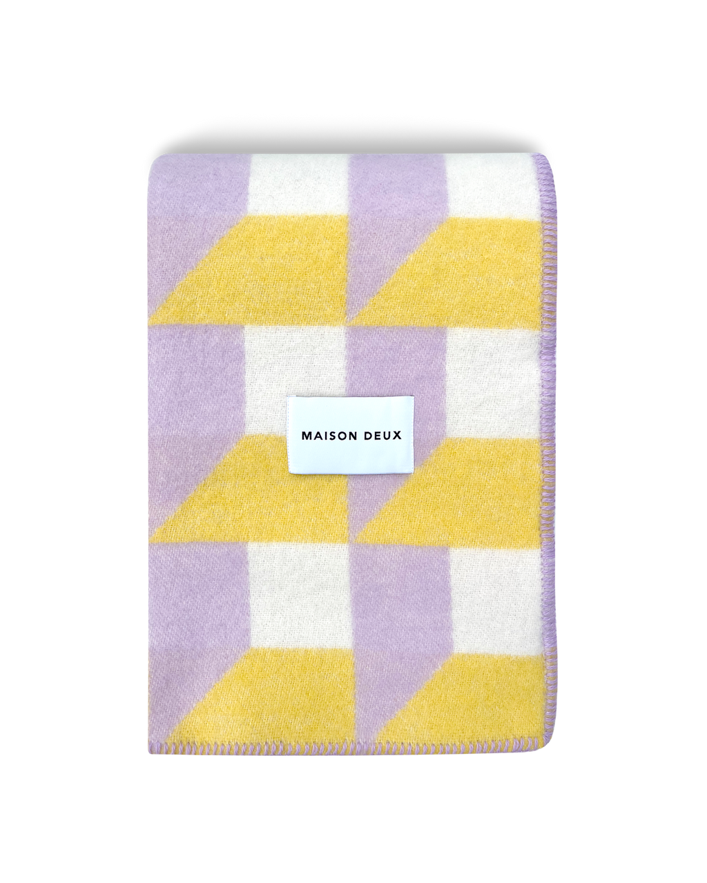Lilac and yellow geometric wool blanket folded with stitched edge detail
