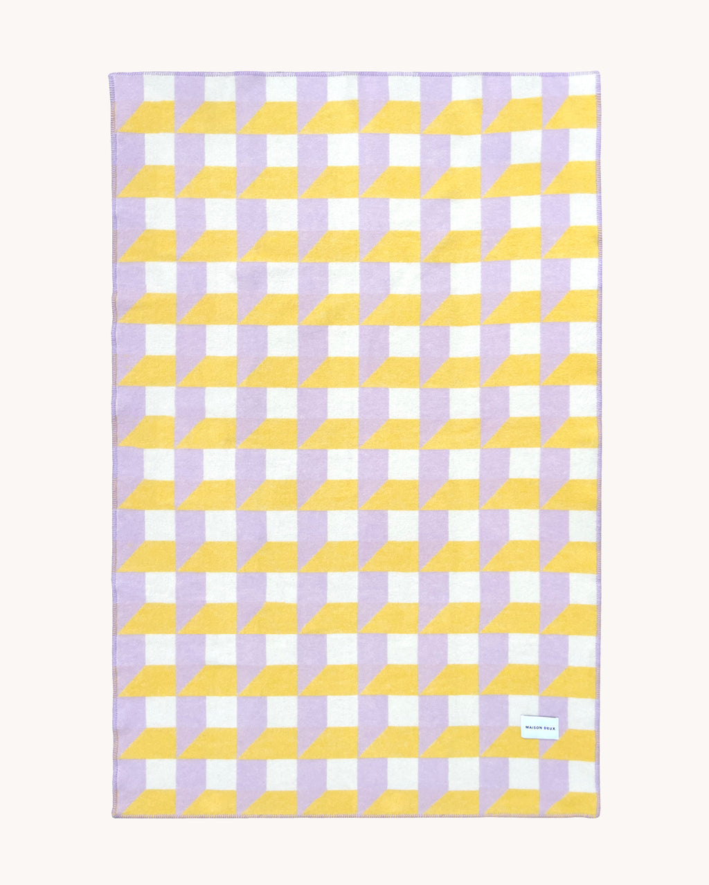 Lilac and yellow geometric wool throw shown flat
