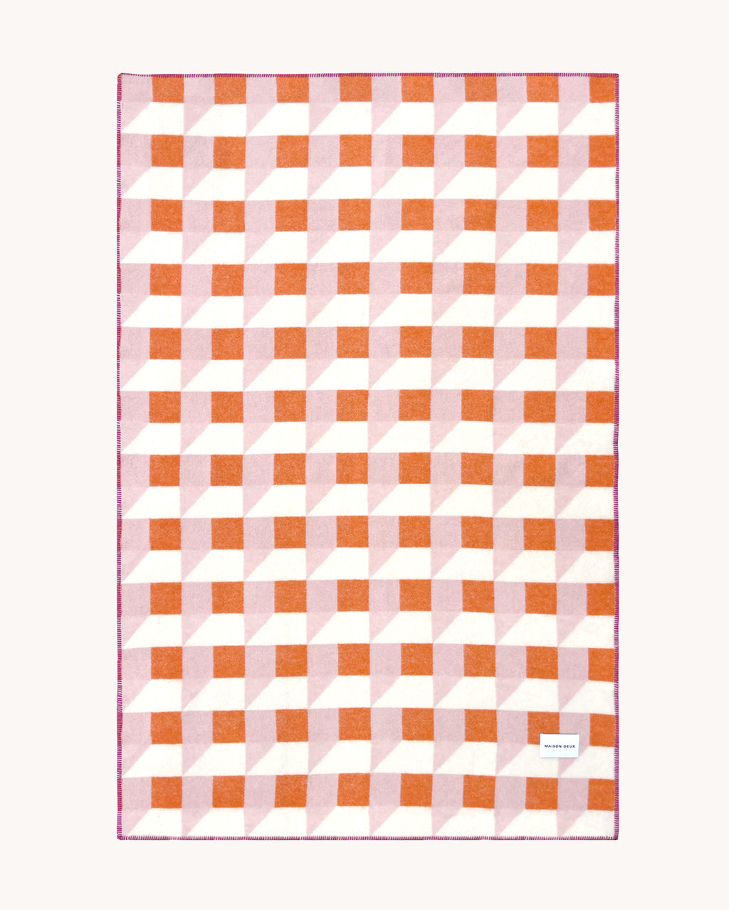 Pink and carrot orange geometric wool throw shown flat
