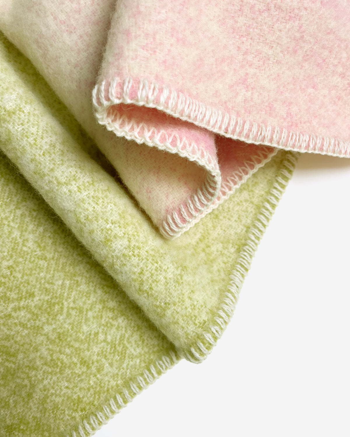  Close-up of folded pink and kiwi green gradient wool plaid with stitched edge