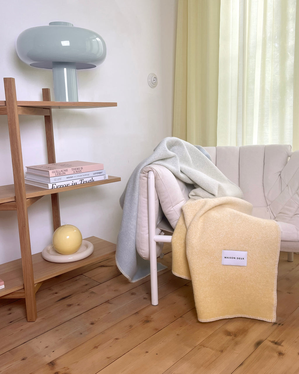 Butter yellow gradient wool throw draped over furniture in styled room

