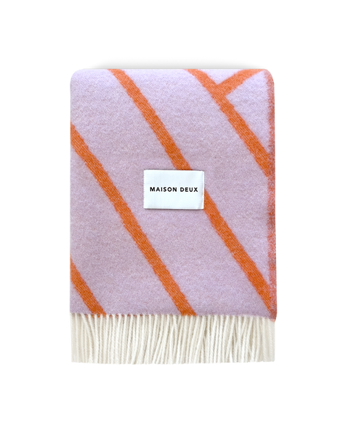 Lilac and orange diagonal striped wool blanket folded with fringe detail
