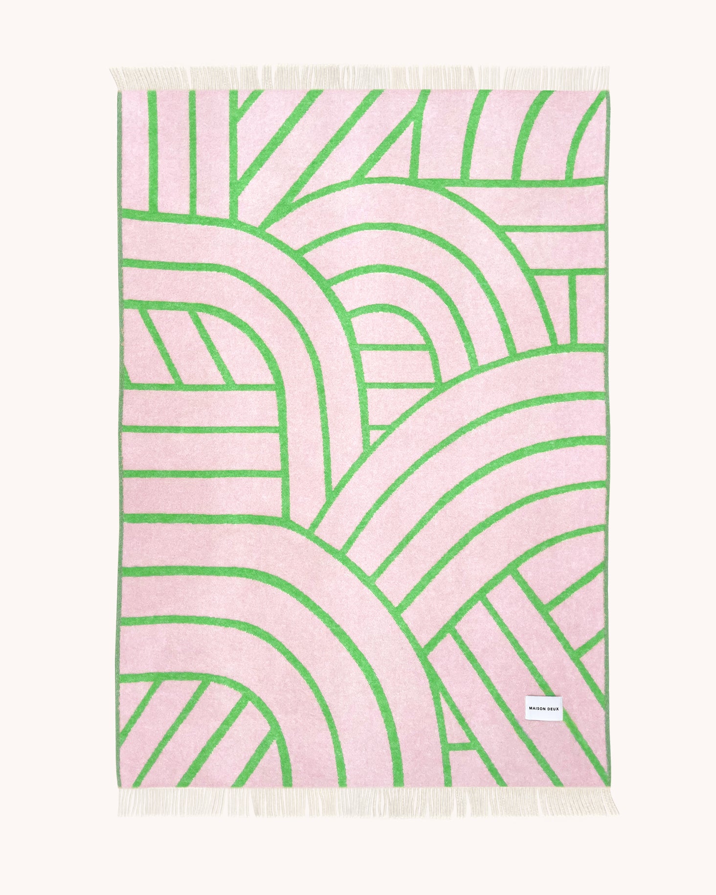 Pink and apple green wool throw with curved arch line pattern
