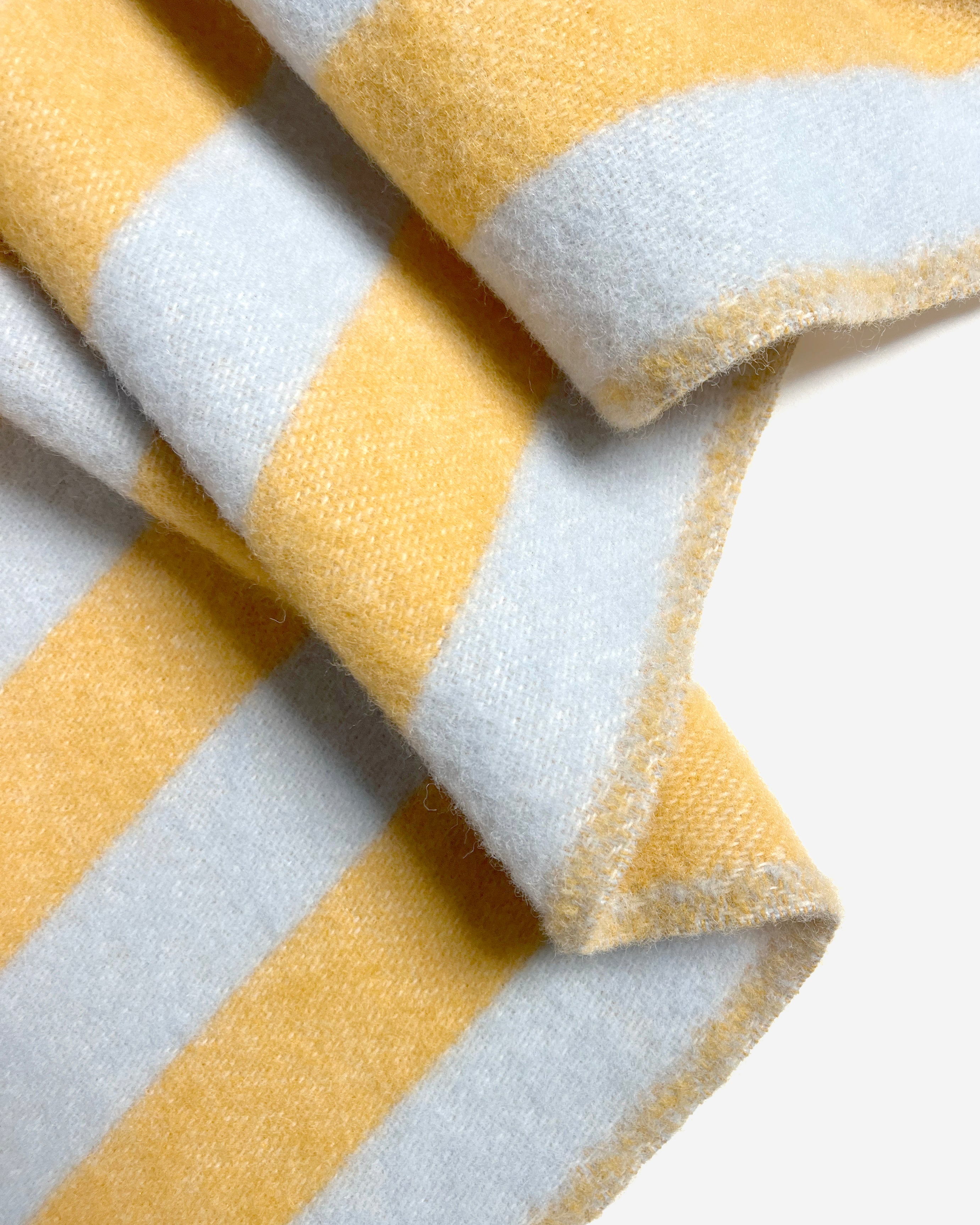 Close-up of folded blue and honey yellow striped wool blanket 