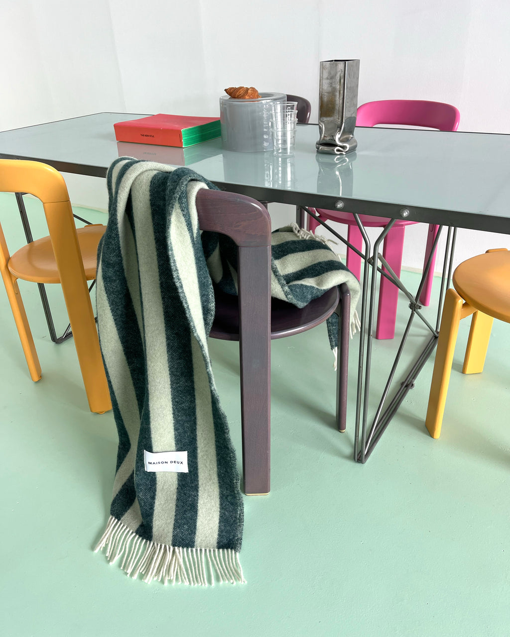 Dark green and sage striped wool plaid draped over dining chair
