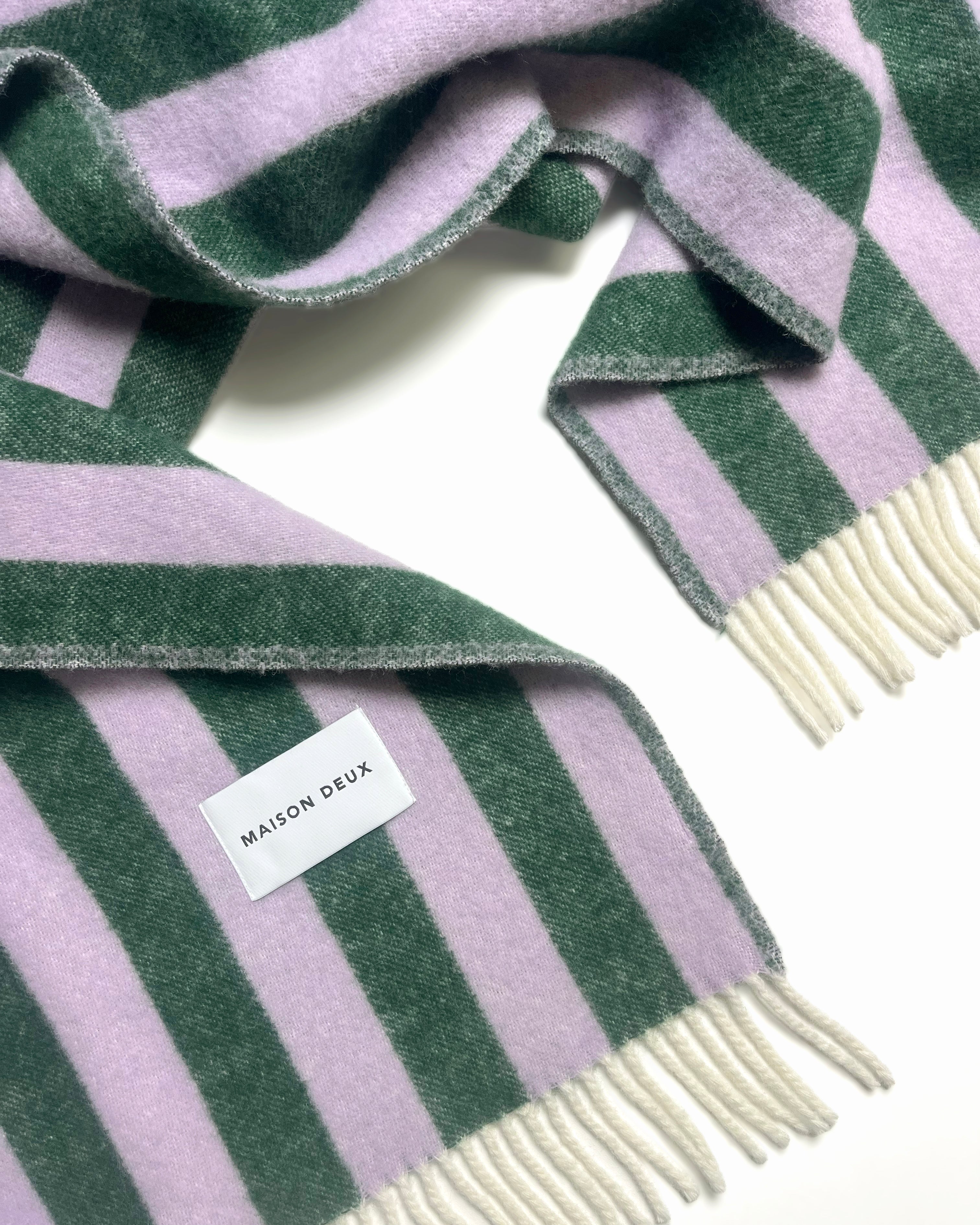 Close-up of lilac and green striped wool plaid with fringe
