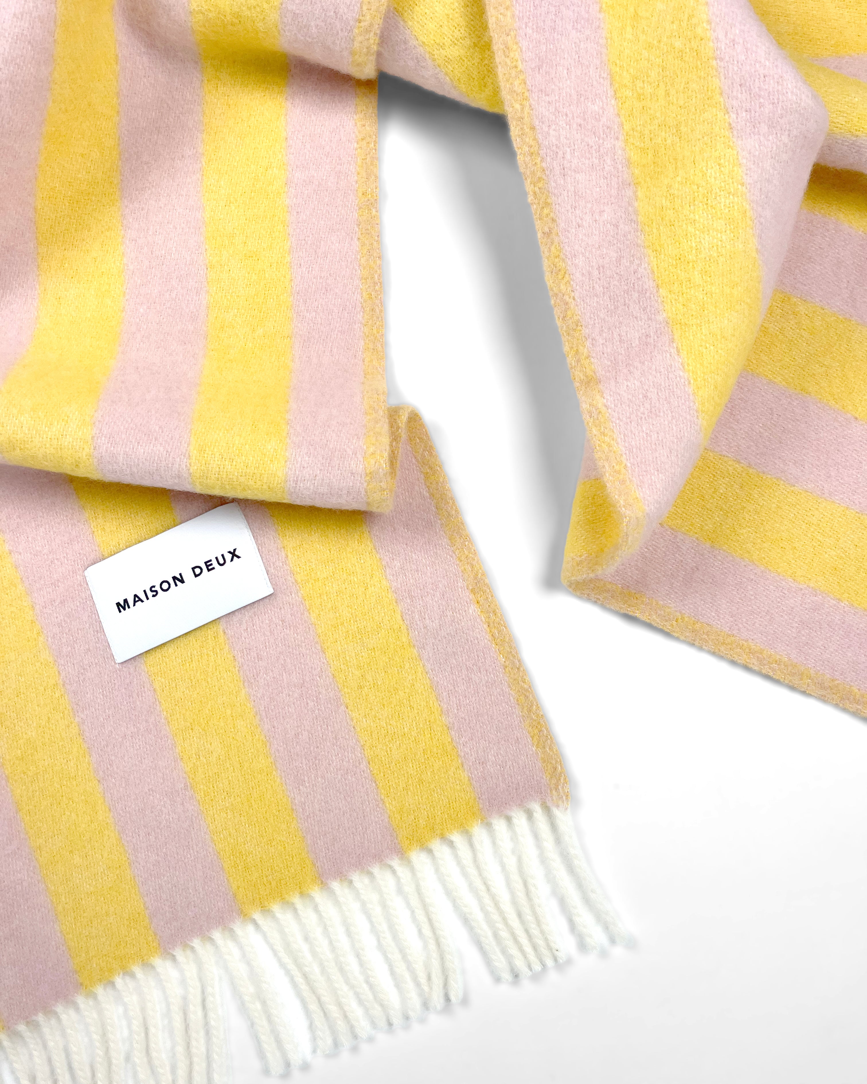 Close-up of pink and yellow striped wool plaid with fringe
