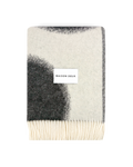 Black and white wool blanket folded with fringe detail
