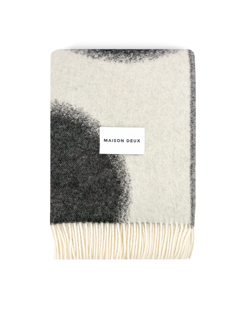 Black and white wool blanket folded with fringe detail
