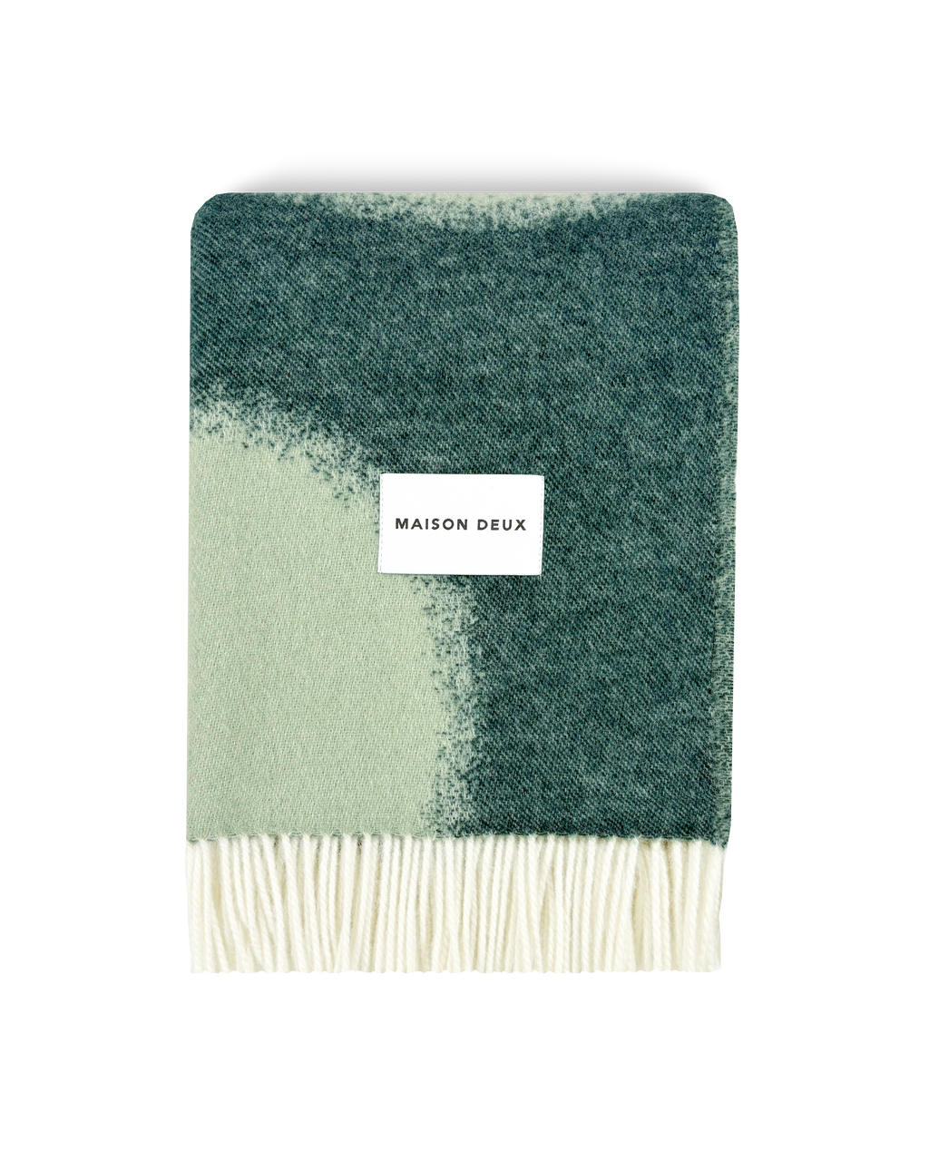 Dark green and sage wool blanket folded with fringe detail
