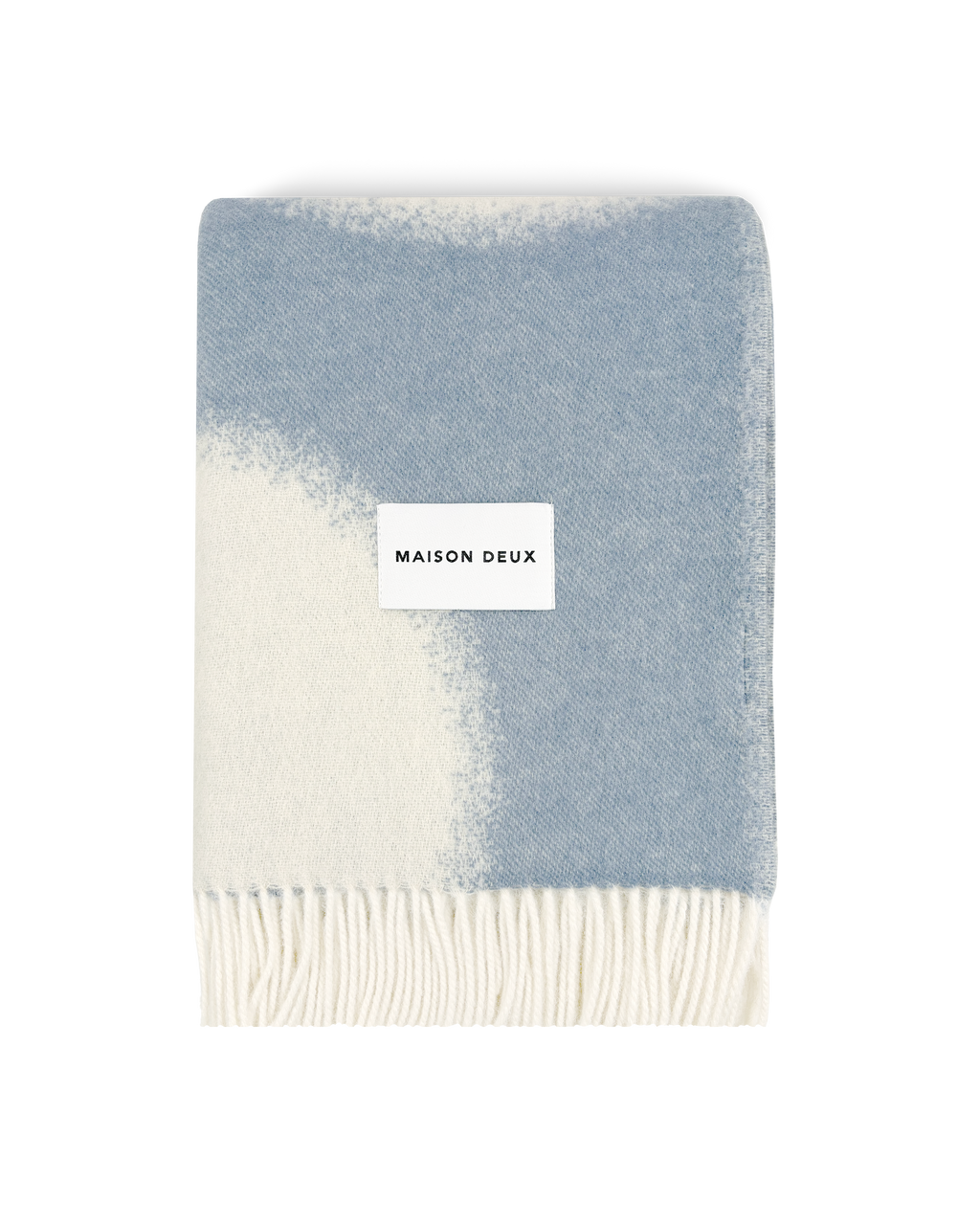 Denim blue and white wool blanket folded with fringe detail
