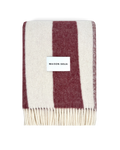 Merlot and white striped wool blanket folded with fringe detail
