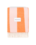 Pink and carrot orange striped wool blanket folded with fringe detail
