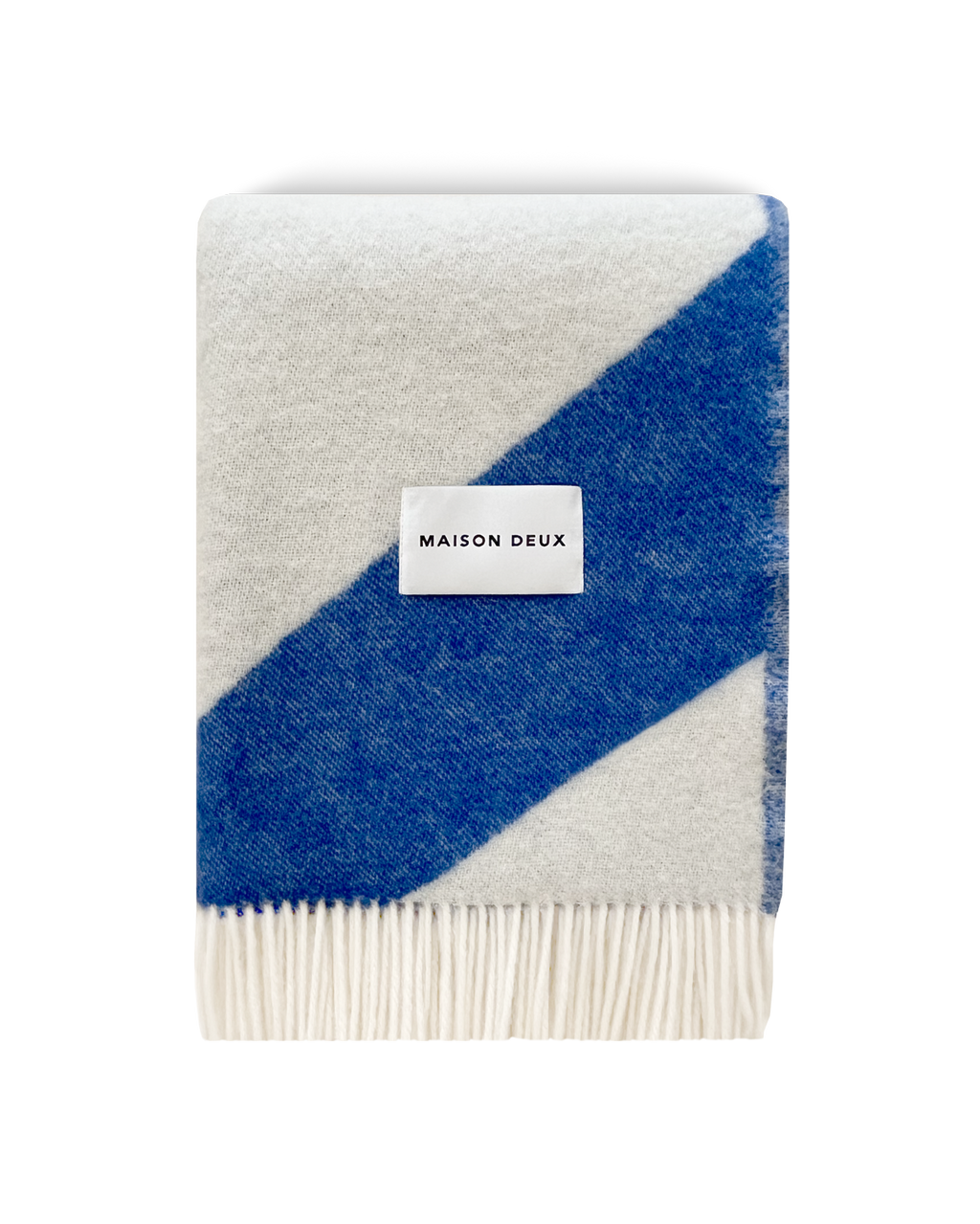 Cobalt blue and white swirl wool blanket folded with fringe detail
