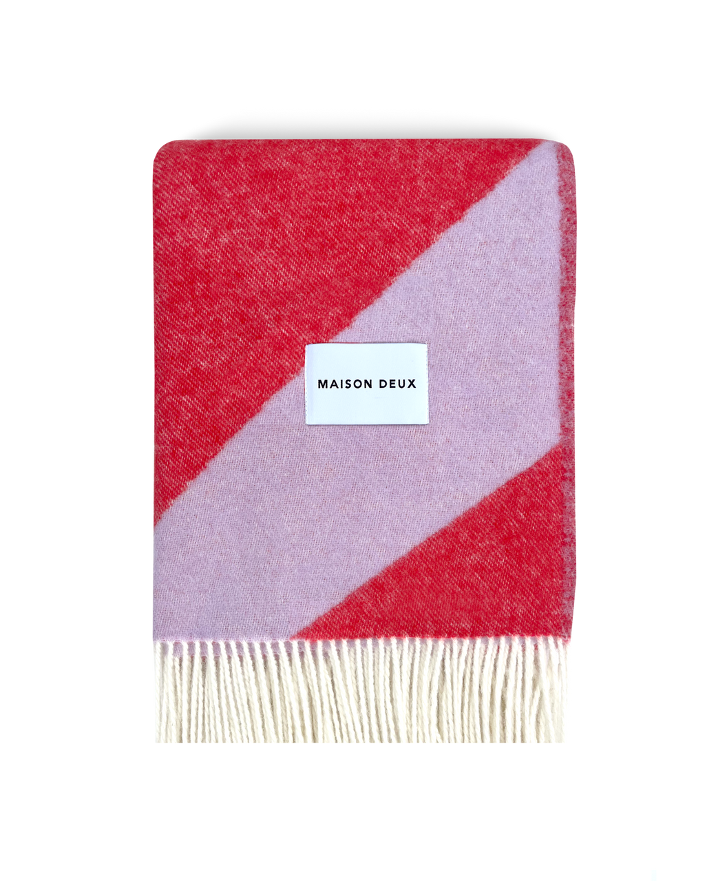 Lilac and scarlet swirl wool blanket folded with fringe detail
