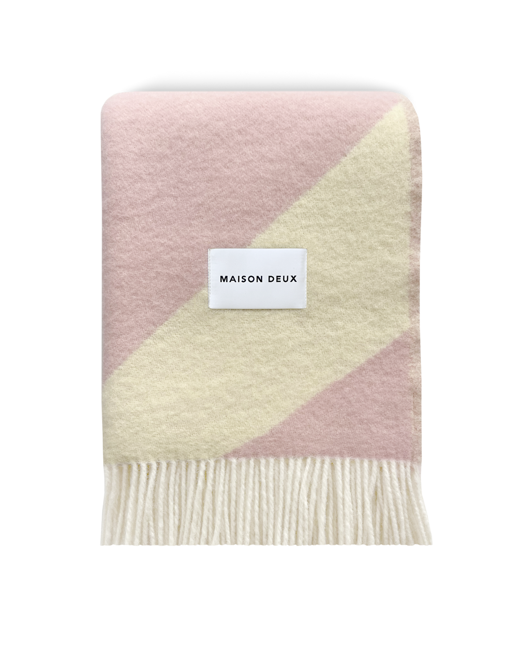 Pink and butter yellow swirl wool blanket folded with fringe detail
