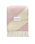 Pink and butter yellow swirl wool blanket folded with fringe detail
